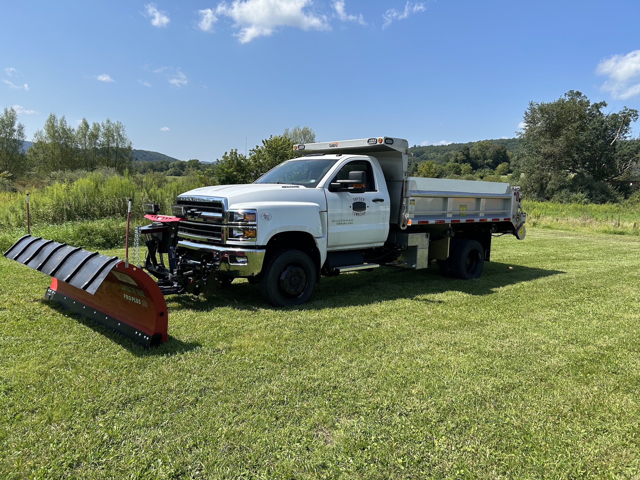 Chevrolet 6500 municipal work truck with a red Western Pro Plus HD snowplow mounted up front and a Galion 304 stainless steel dump body.